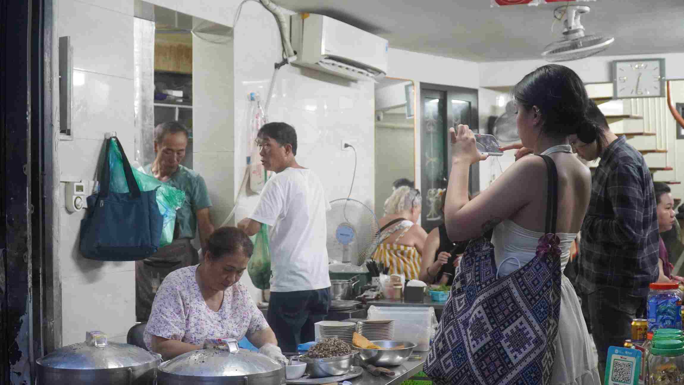 Chị Reian thích thú lưu giữ những hình ảnh món bánh cuốn. Ảnh: Minh Vũ