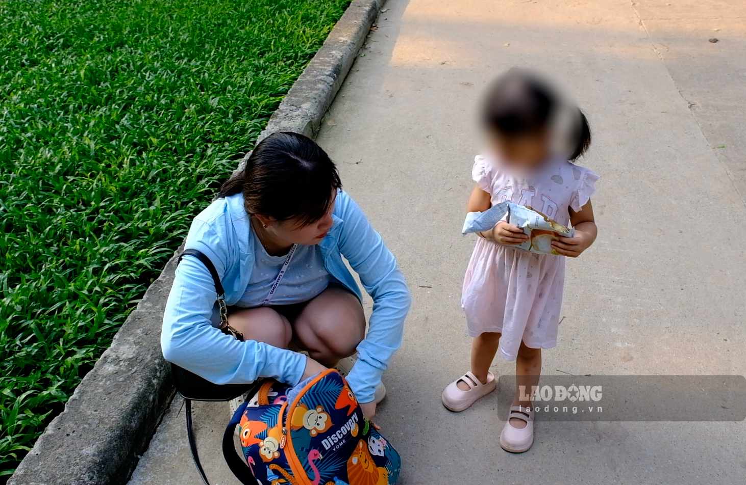 Chị Nguyễn Phương Anh chủ động vệ sinh sạch sẽ cho con gái khi đưa con ra khu vực công cộng vui chơi để phòng bệnh Adeno. Ảnh: Hân Nghiên
