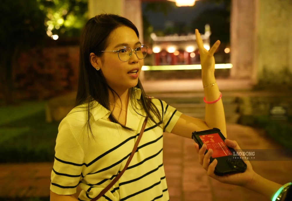 Chị Vũ Thị Thu Uyên (Ninh Bình) chia sẻ cảm nhận sau khi tham gia tour du lịch đêm tại Văn Miếu - Quốc Tử Giám. Ảnh: Viên Nguyễn.