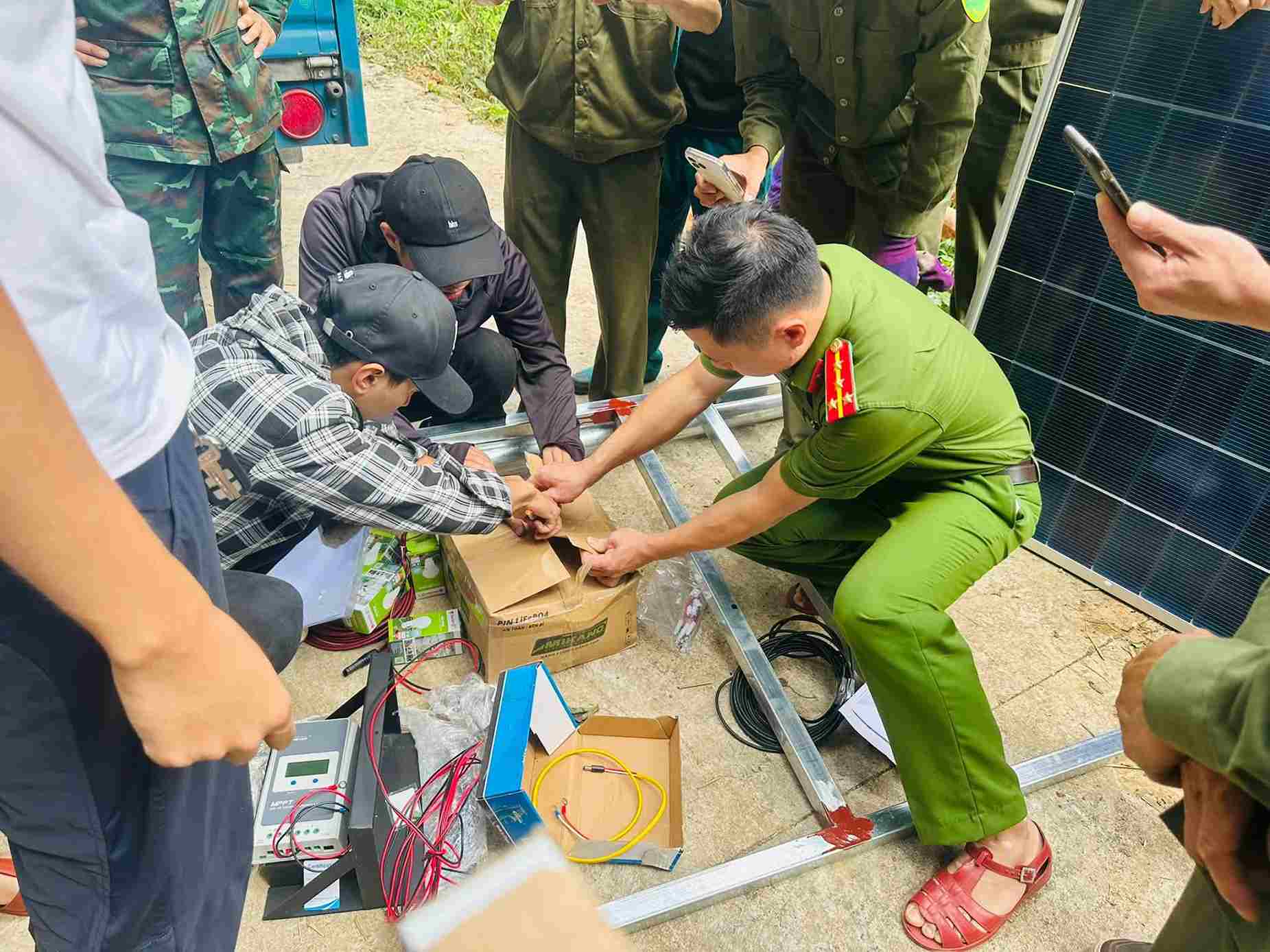 Lực lượng chức năng phối hợp lắp đặt các tấm pin. Ảnh: Công an xã Hòa An